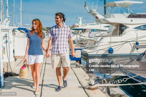 hispanic couple walking on dock at marina - limassol photos et images de collection