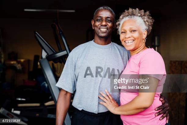 black woman smiling in garage - veterans stock-fotos und bilder