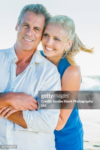 caucasian couple hugging at beach - myrtle beach foto e immagini stock