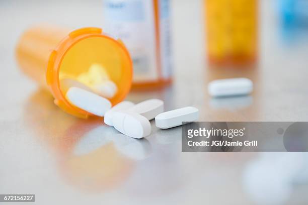 pills in prescription bottle - prescription medicine stock pictures, royalty-free photos & images