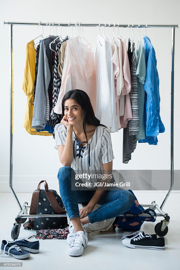 Indian woman sitting on clothing rack