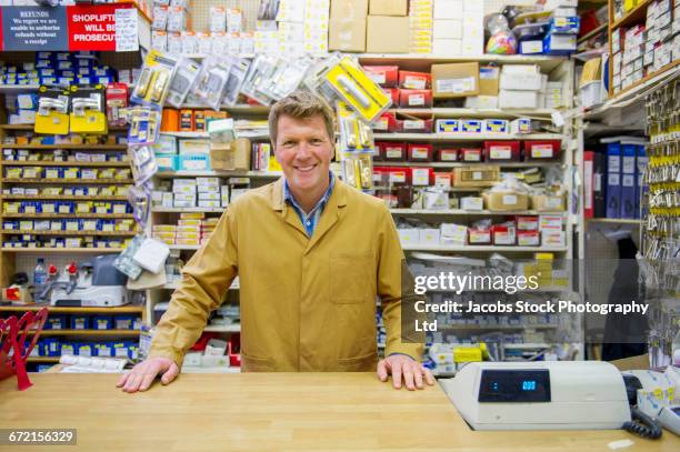 caucasian worker at cash register in hardware store - kassierer stock-fotos und bilder