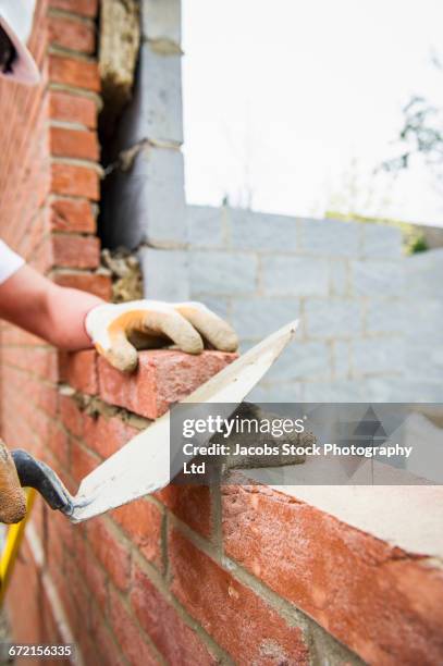 caucasian construction worker laying bricks with mortar - spalding place bildbanksfoton och bilder