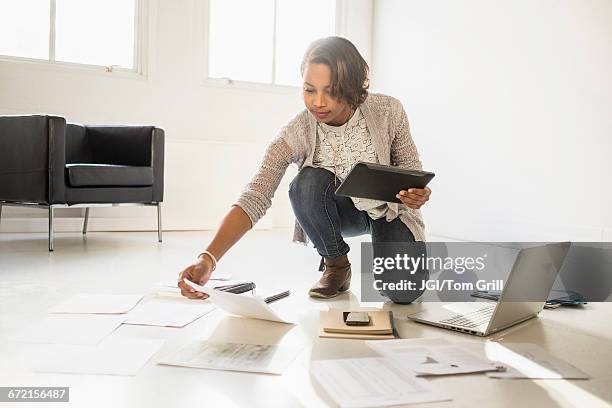 black businesswoman using laptop and digital tablet on floor - start a new business stock pictures, royalty-free photos & images