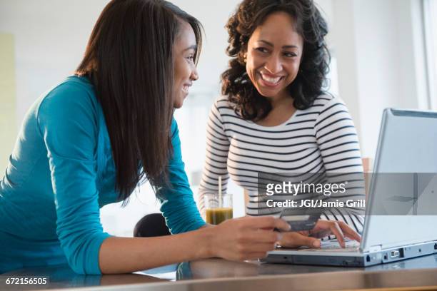 mother and daughter online whopping with credit card and laptop - 15 girl stock pictures, royalty-free photos & images