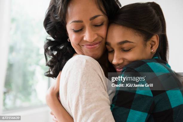 mother and daughter hugging - african girl hug stock pictures, royalty-free photos & images