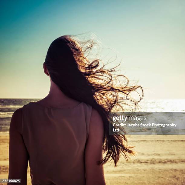 hair of caucasian woman blowing in wind at beach - human hair strand stock pictures, royalty-free photos & images