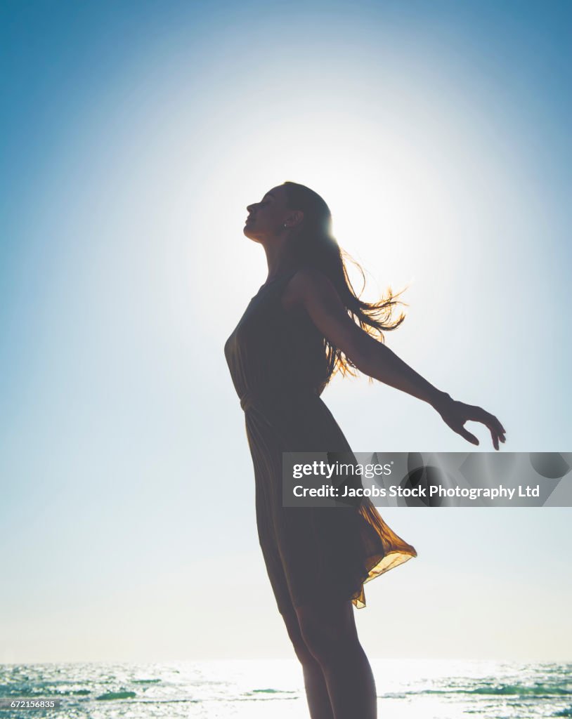 Silhouette of profile of Caucasian woman at beach