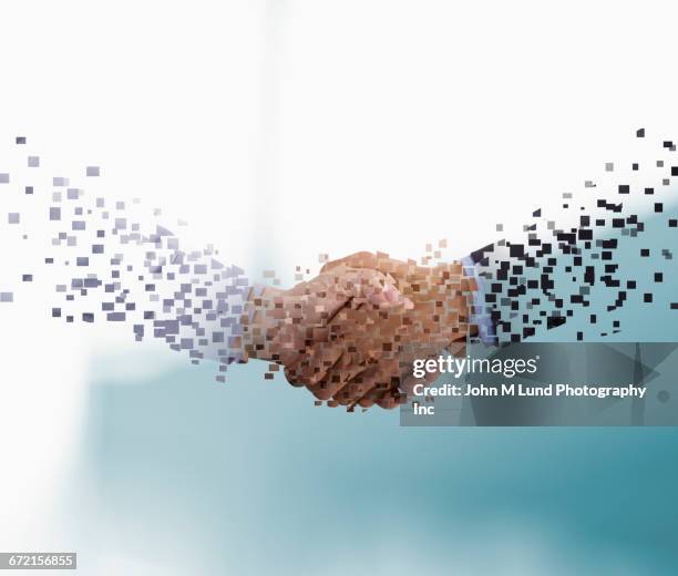 pixels forming arms of businessmen shaking hands - computer part stock-fotos und bilder