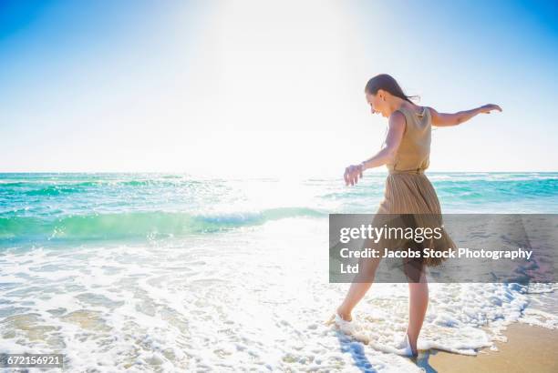 caucasian woman wading in waves at ocean beach - myrtle beach foto e immagini stock