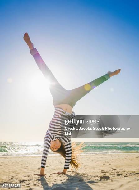 caucasian woman doing cartwheel on beach - cartwheel stock pictures, royalty-free photos & images