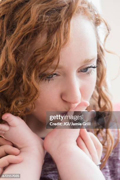 caucasian woman kissing foot of baby son - kissing feet stock pictures, royalty-free photos & images