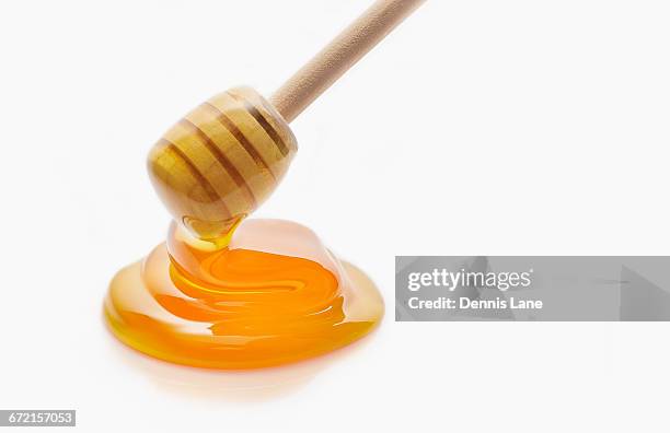 honey dripping from honey dipper - honey stock pictures, royalty-free photos & images