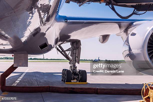 underbelly of airplane at airport - landing gear stock-fotos und bilder