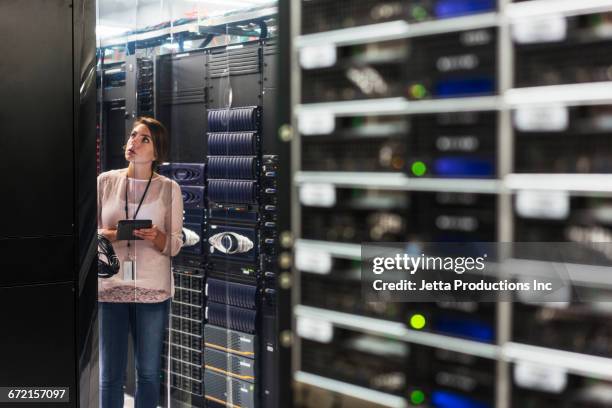 caucasian technician using digital tablet in computer server room - old computer equipment stock pictures, royalty-free photos & images