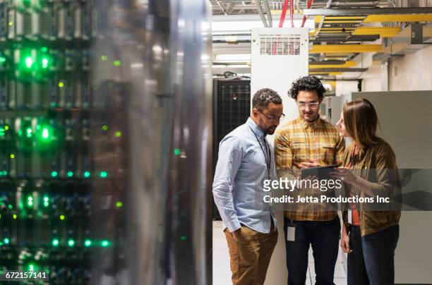 technicians using digital tablet in computer server room - good technology inc stock pictures, royalty-free photos & images