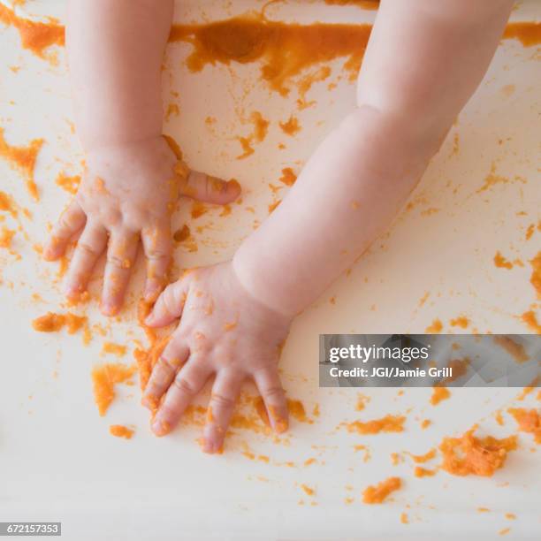 hands of caucasian baby girl self-feeding mashed sweet potato - mashed sweet potato stock pictures, royalty-free photos & images