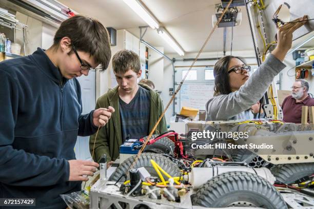 robotics students adjusting machinery - school fair stock pictures, royalty-free photos & images