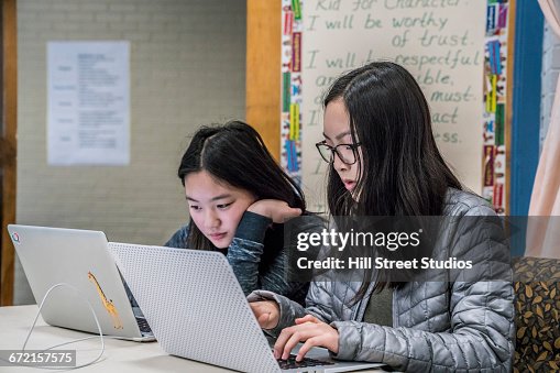 Asian students using laptops at table Asian students using laptops at table