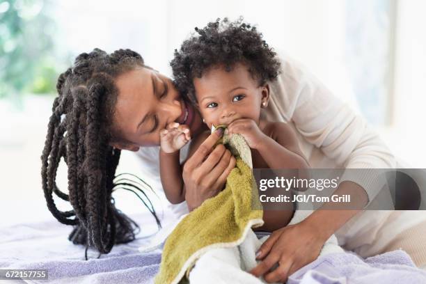 black woman drying baby daughter with towels - mother daughter towel fotografías e imágenes de stock