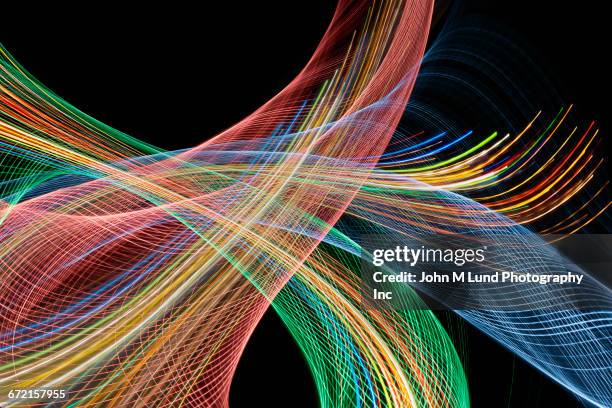 multicolor curving lines flowing on black background - data stream stock illustrations