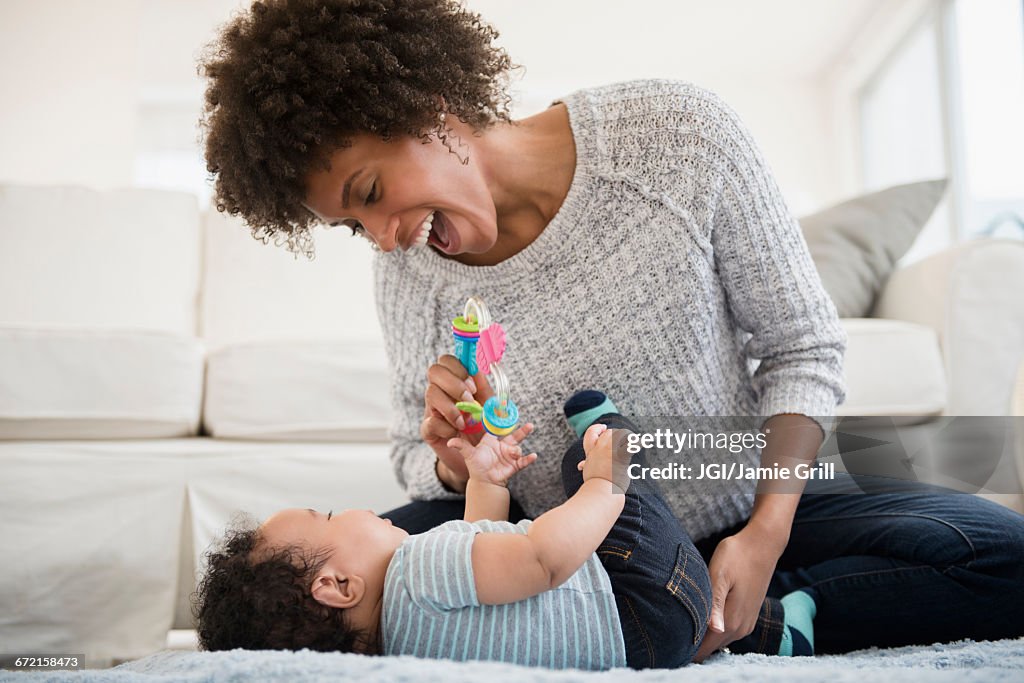 Mother playing with baby son on floor