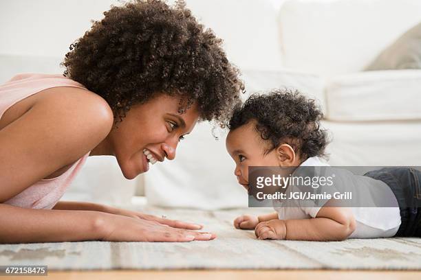 mother playing face to face with baby son on floor - 2 5 mois photos et images de collection