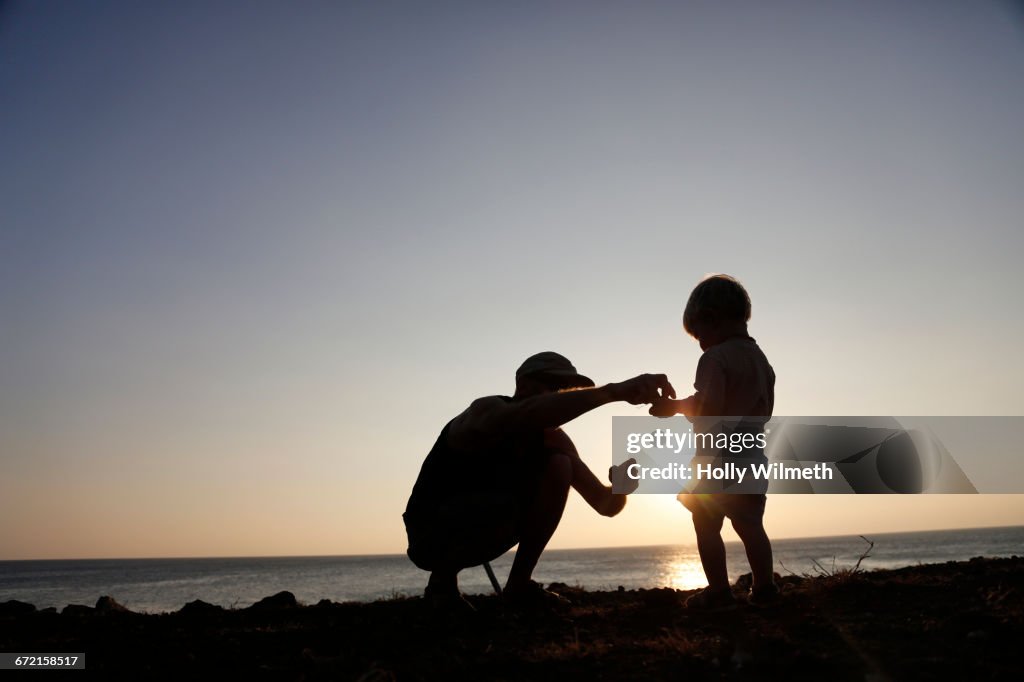 Silhouette of father and son exploring at beach