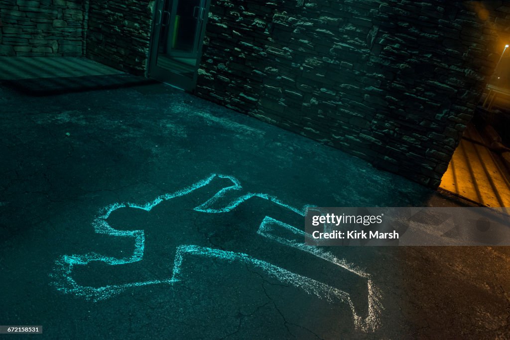 Chalk outline of body of victim on pavement