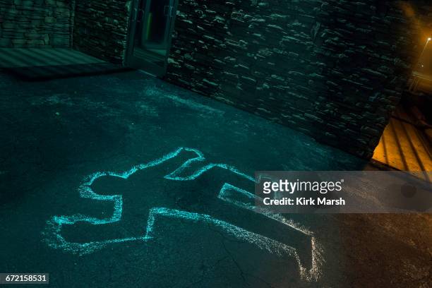 chalk outline of body of victim on pavement - dead body stockfoto's en -beelden