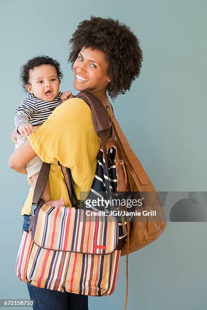 mother carrying three bags and baby son - diaper bag stockfoto's en -beelden