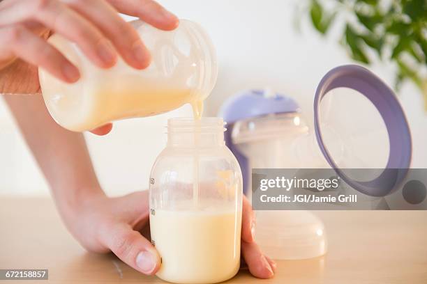 caucasian woman pouring breast milk into bottle - milk pumping ストックフォトと画像