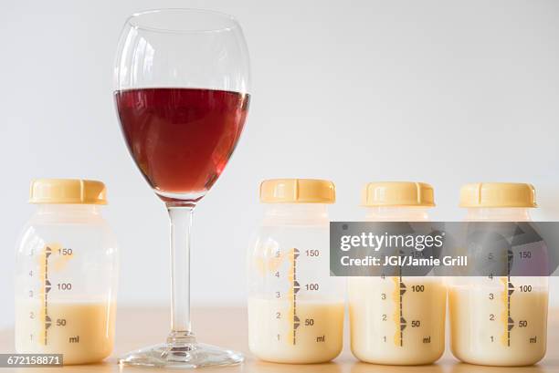 red wine and bottles of breast milk - milk pumping ストックフォトと画像