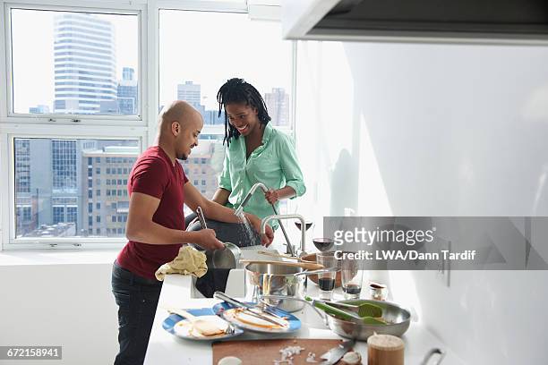 couple washing pot in modern urban domestic kitchen - domestic life imagens e fotografias de stock