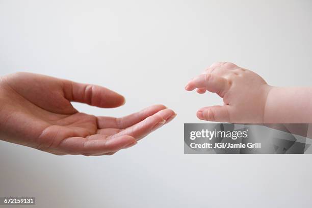 hand of mother reaching for hand of baby son - baby isolated stockfoto's en -beelden