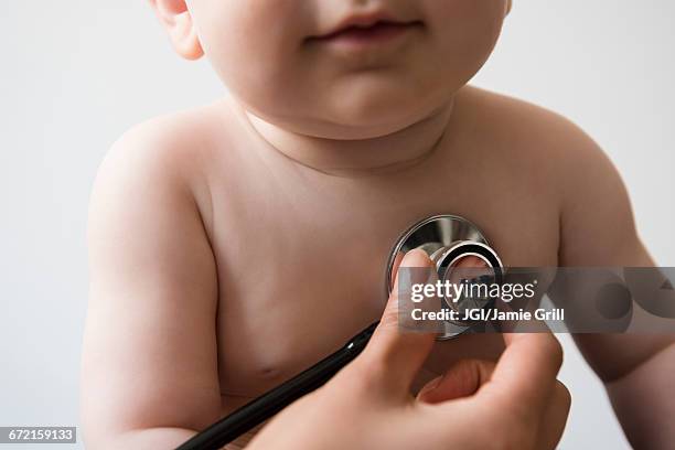 doctor listening to chest of baby boy with stethoscope - doctor and baby stockfoto's en -beelden