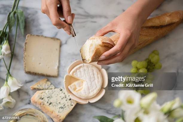 hispanic woman spreading cheese on bread - cheese board photos et images de collection