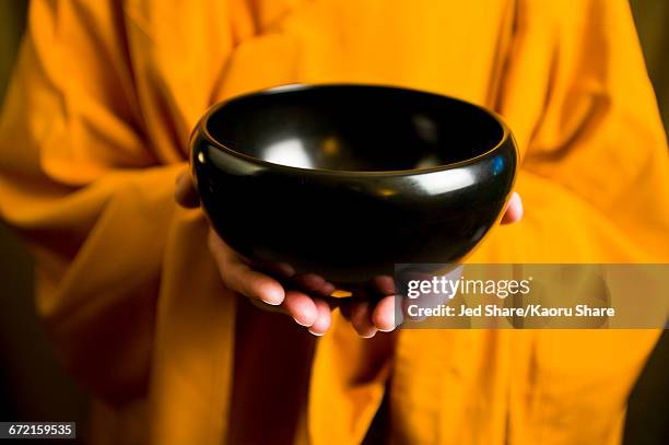 monk in orange robe holding black bowl - alm seekers stock pictures, royalty-free photos & images