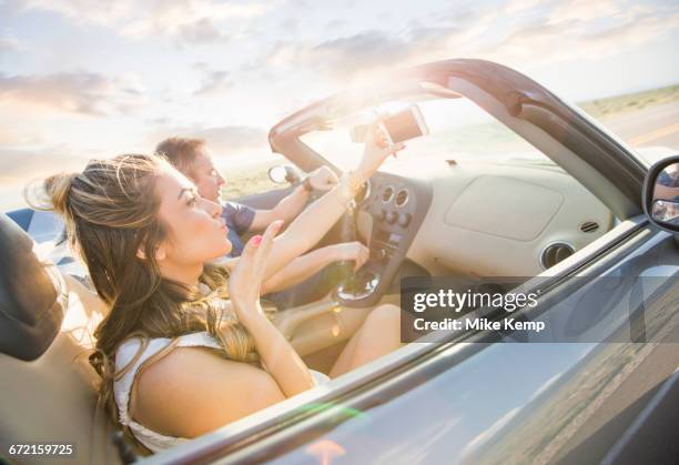 caucasian couple driving in sports car - driving uphill stock pictures, royalty-free photos & images
