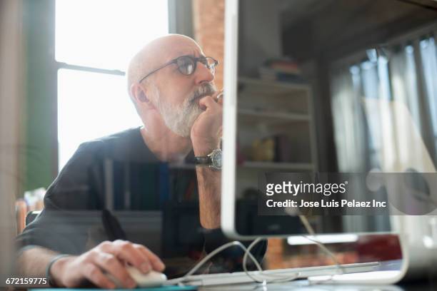 hispanic businessman using computer - mature reading computer stock pictures, royalty-free photos & images