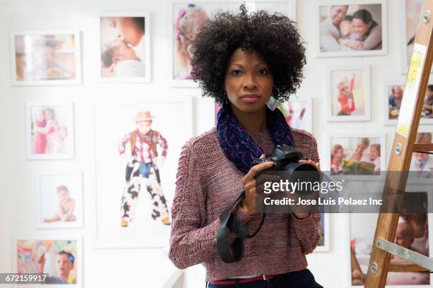 black photographer holding camera in studio - photographer stock-fotos und bilder