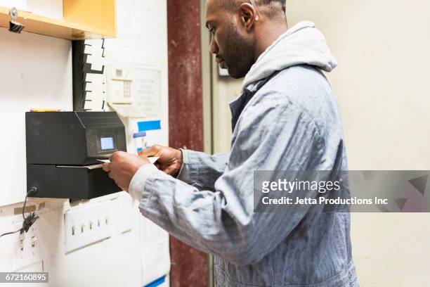 worker stamping time card in factory - primo turno foto e immagini stock