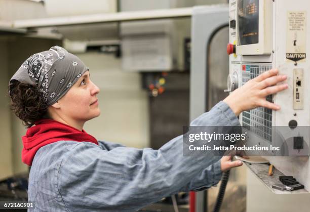 hispanic worker using control panel in factory - stechuhr stock-fotos und bilder