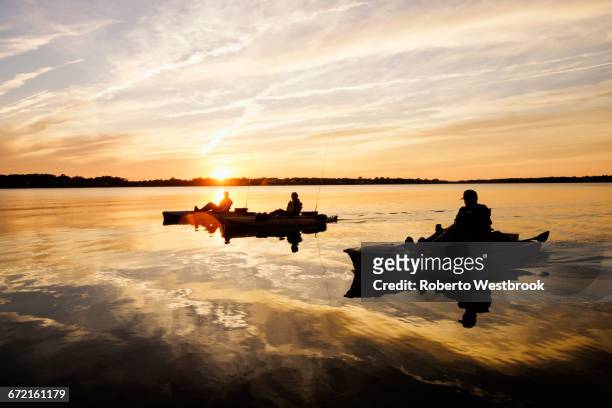 silhouette of people fly fishing in kayaks on river - virginia beach 個照片及圖片檔