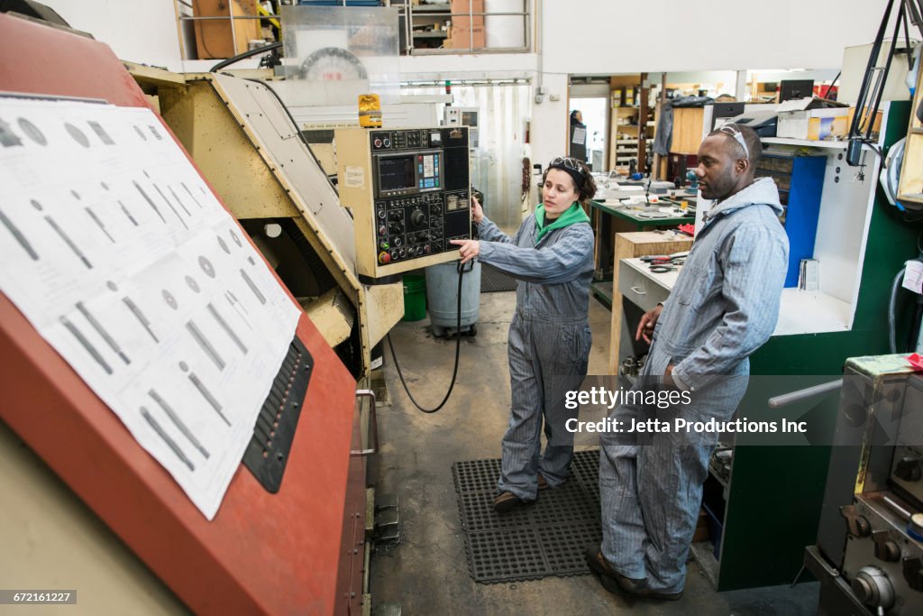 Workers using control panel in factory