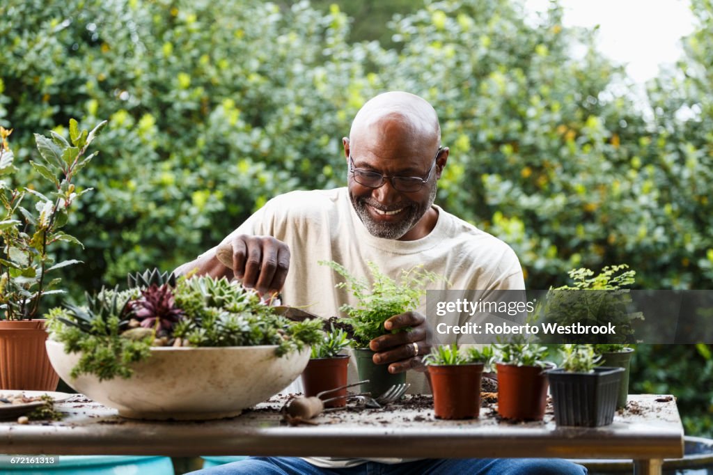 Black man gardening at table outdoors