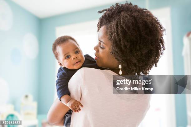 black mother carrying baby son - black baby 個照片及圖片檔