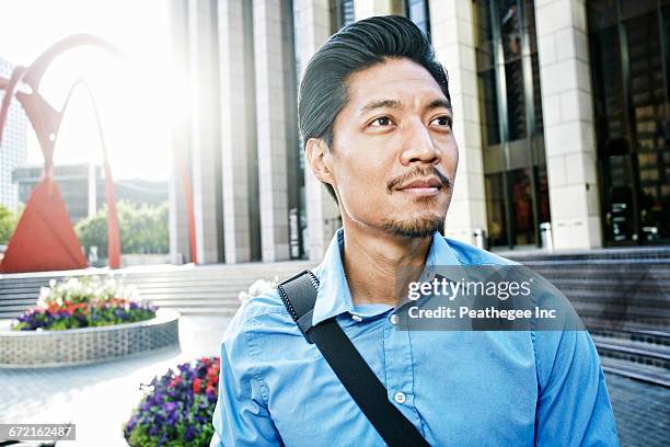 mixed race businessman in plaza outdoors - modern sculpture stock pictures, royalty-free photos & images