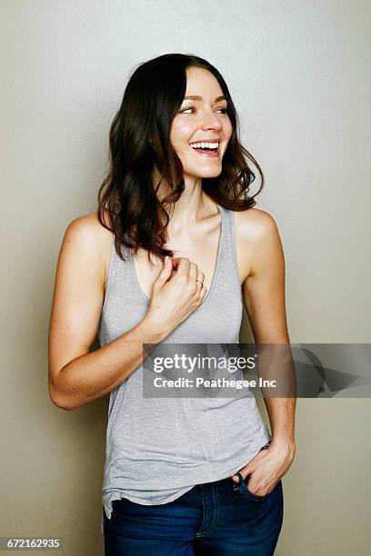 caucasian woman laughing near wall - woman portrait waist up stock pictures, royalty-free photos & images