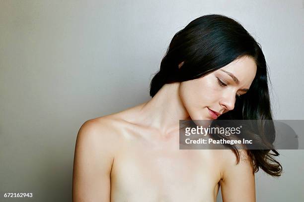 pensive naked caucasian woman near wall - beautiful woman chest fotografías e imágenes de stock